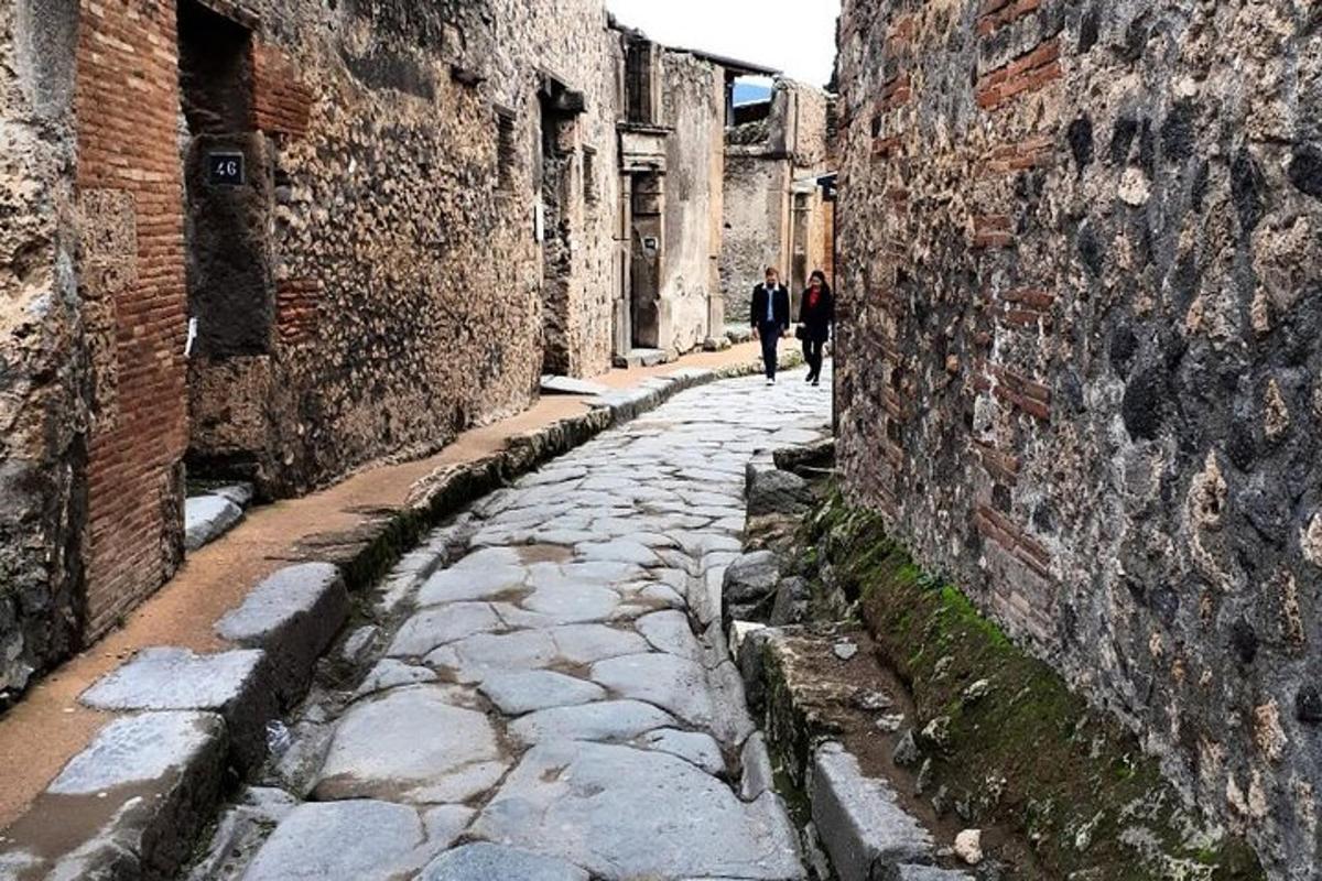 due persone che camminano lungo un vicolo tra due edifici