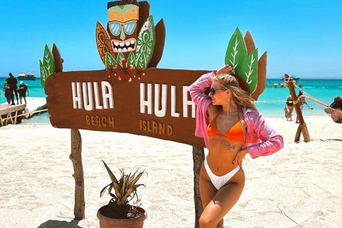 o femeie în bikini stând lângă un semn pe plajă