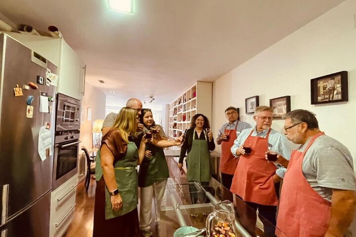 a group of people standing in a kitchen drinking wine