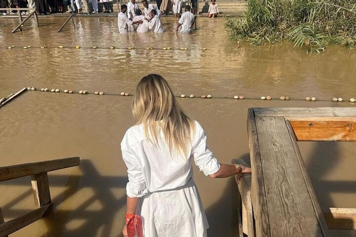 a woman in a white dress looking at the water