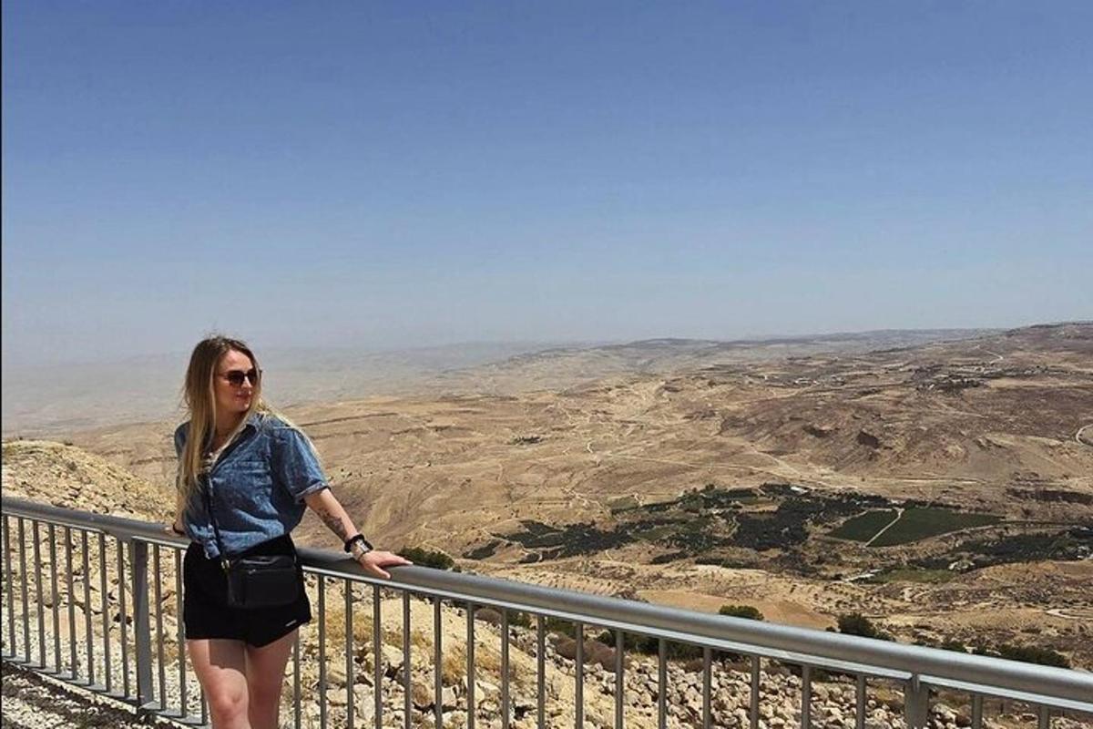 a woman standing on top of a balcony overlooking the mountains