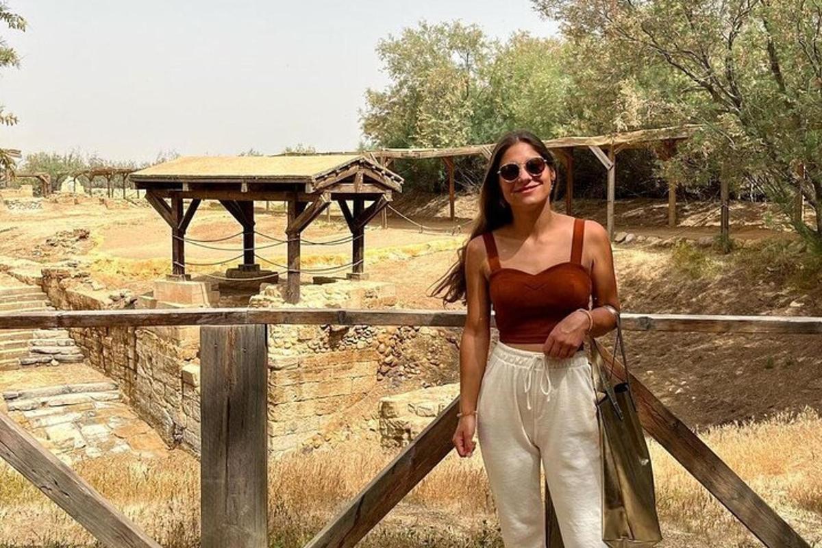 a woman is standing next to a fence