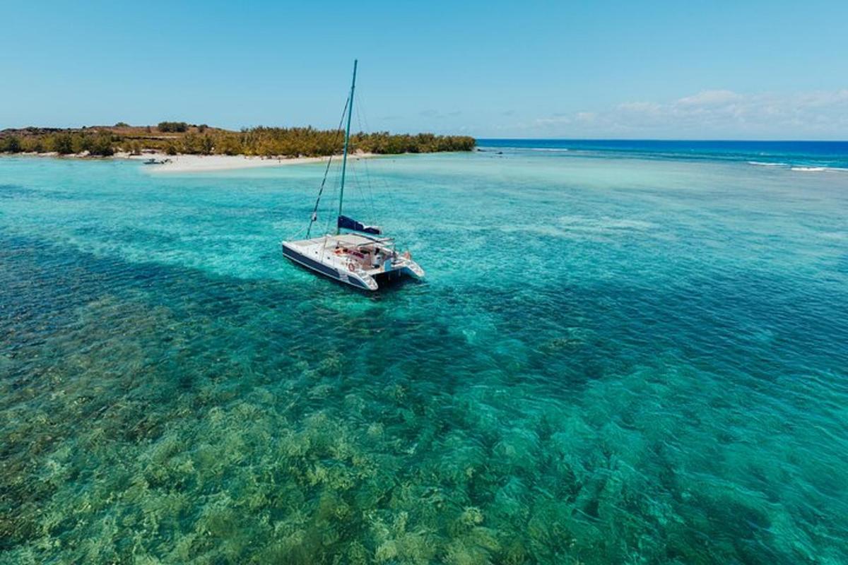 una barca a vela in acqua vicino a una spiaggia