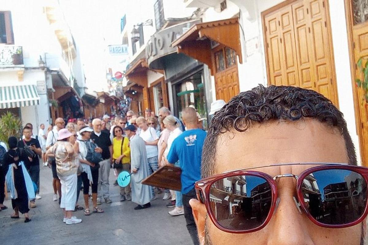 bir kalabalığın önünde güneş gözlüğü takan bir adam