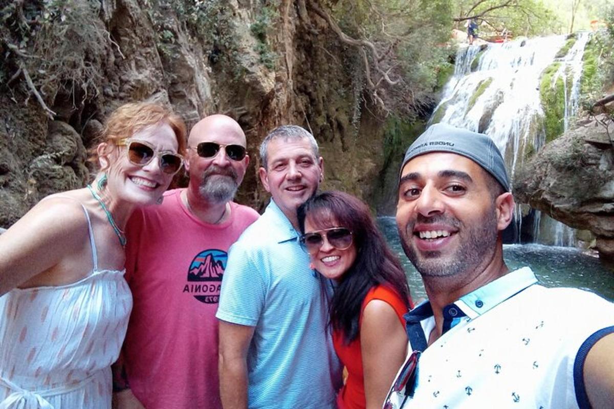 Un grupo de personas de pie frente a una cascada.