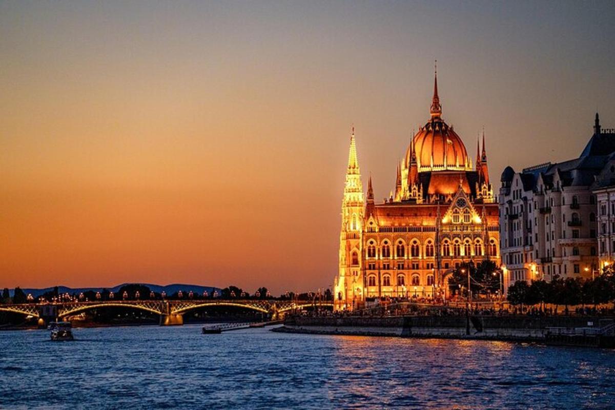 a lit up building with a bridge next to a river