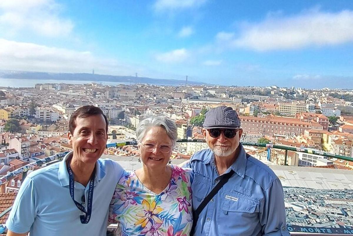 tři lidé pózují pro fotografii na vrcholu města