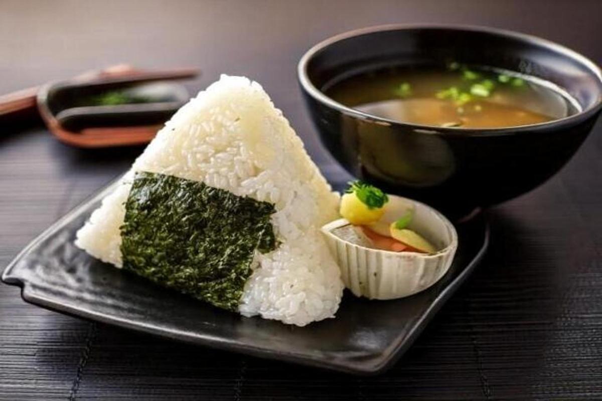 um prato com um pedaço de sushi e uma tigela de sopa