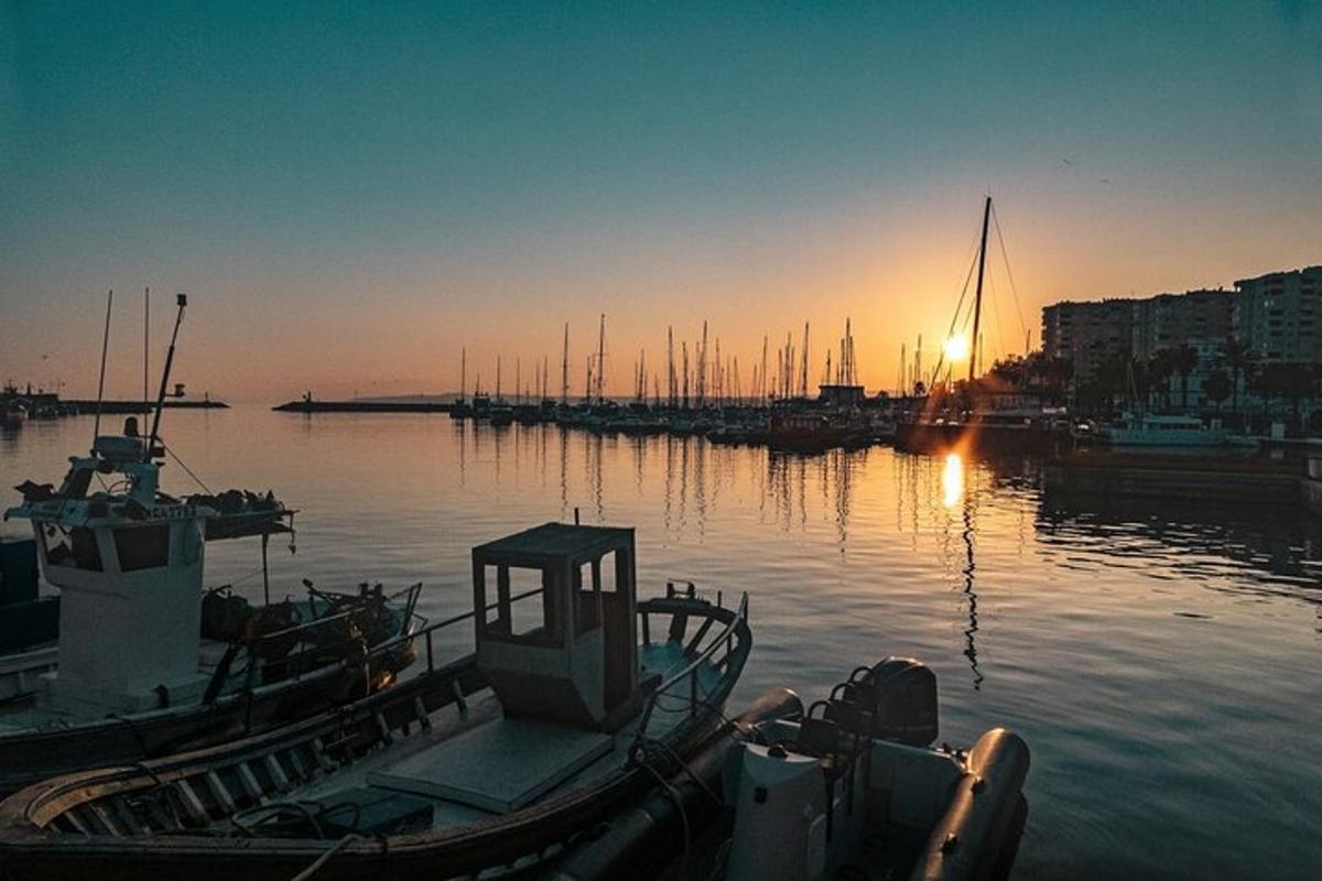 una barca attraccata in un porto con il sole che tramonta