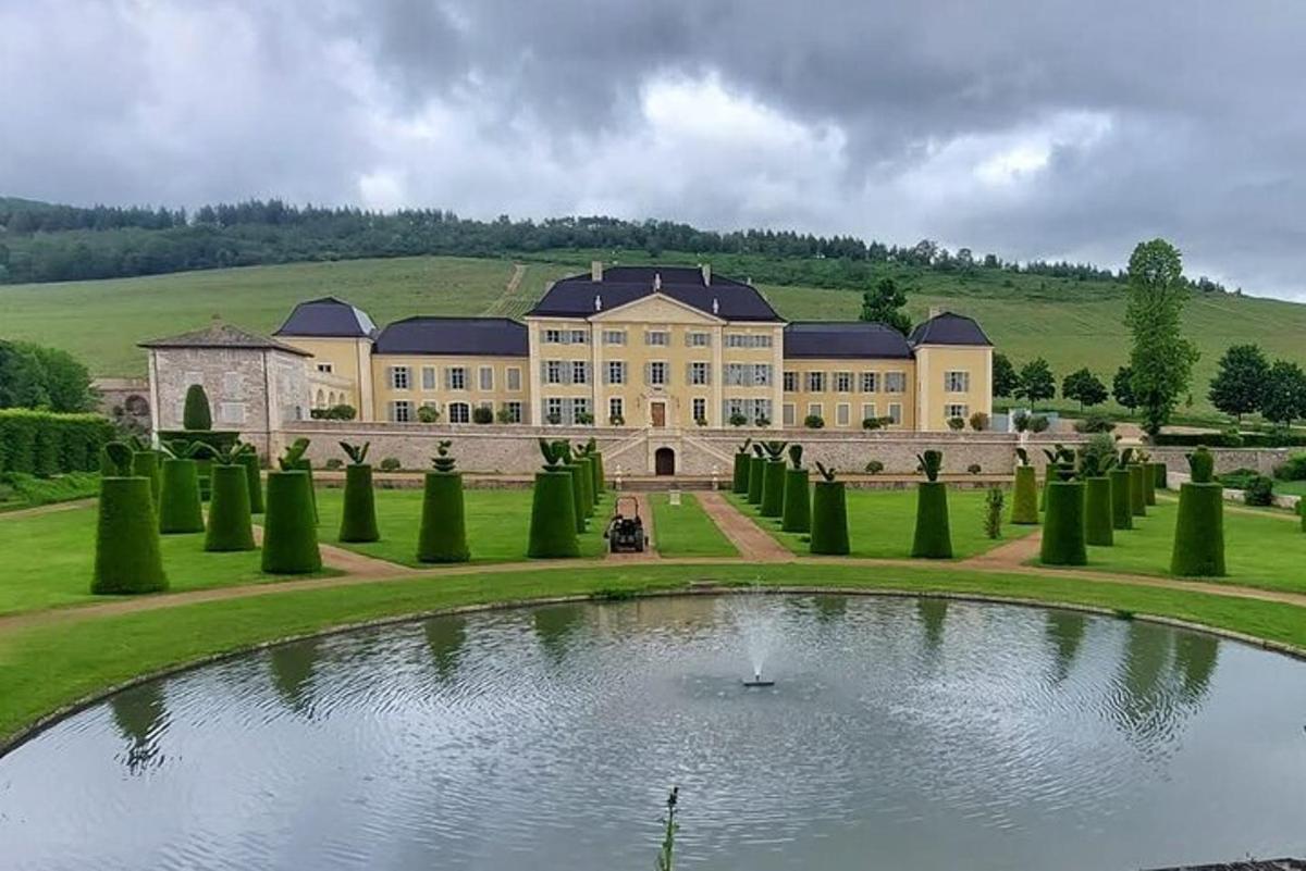 a large building with a pond in the middle of a garden