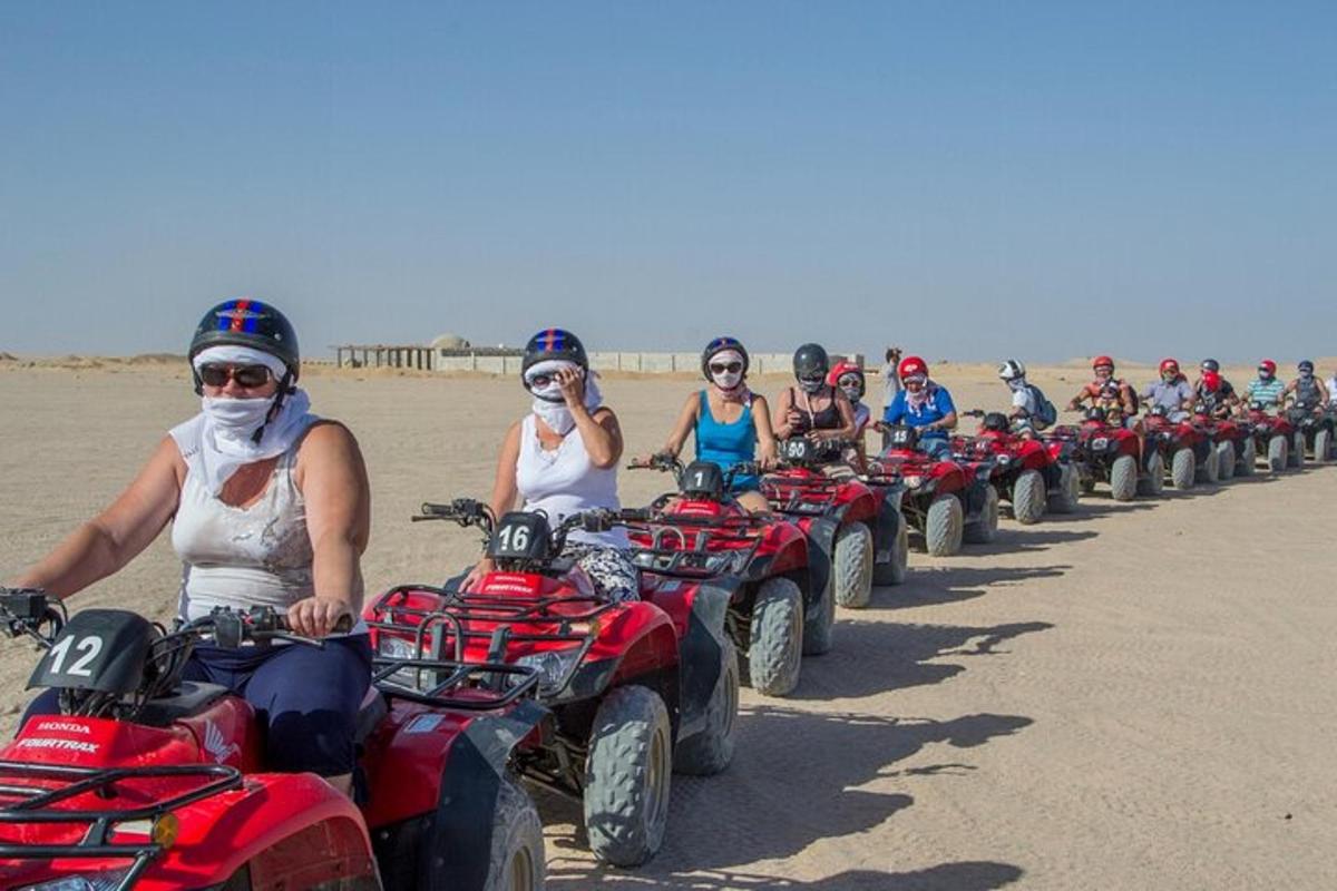 un grup de oameni care se plimbă cu ATV-uri pe plajă