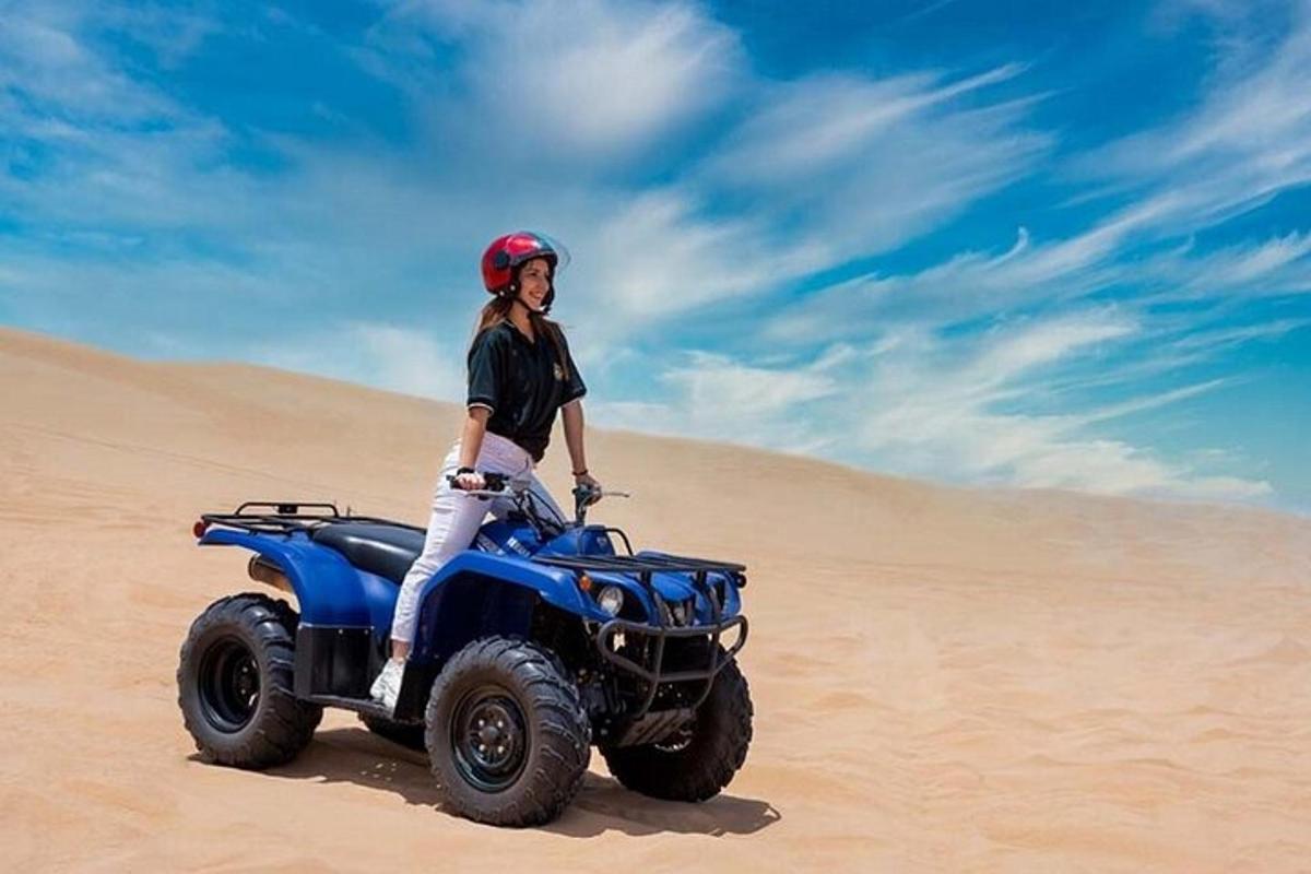 una donna in piedi su un quad nel deserto