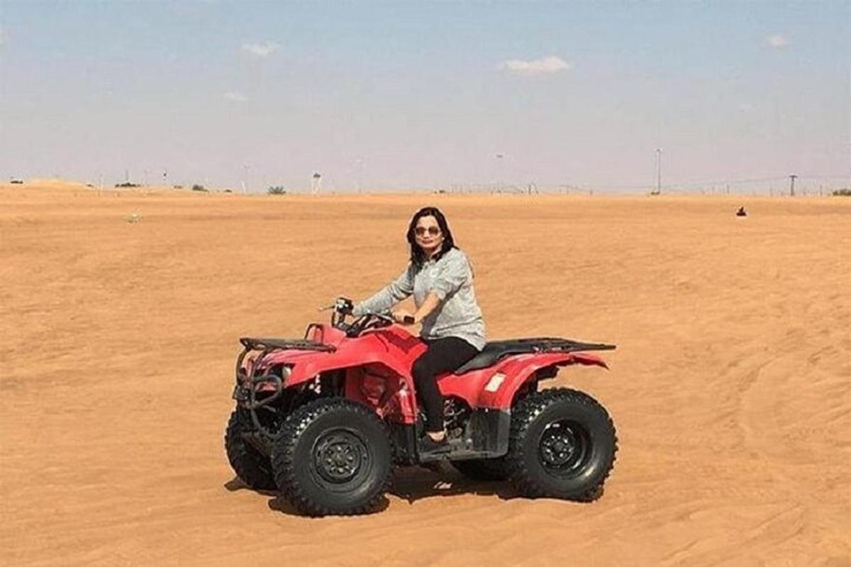 žena jedoucí na čtyřkolce v poušti