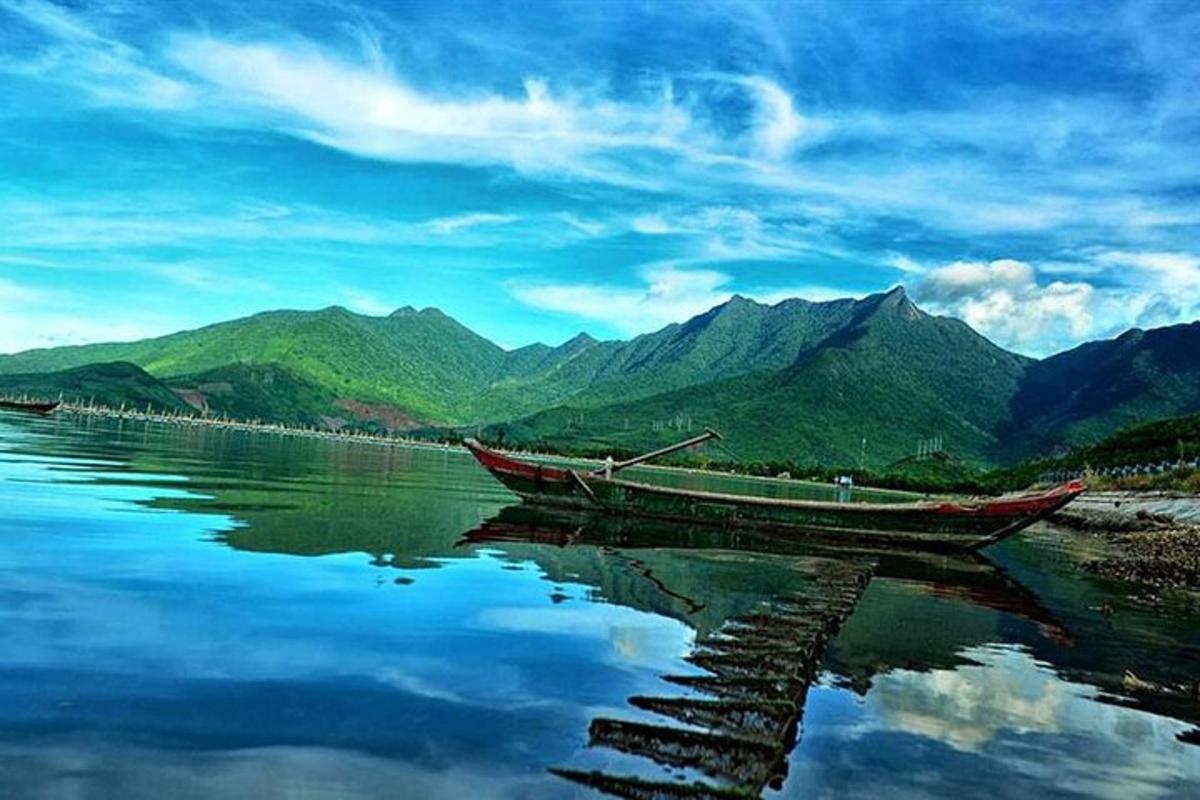 una barca sull'acqua con le montagne sullo sfondo