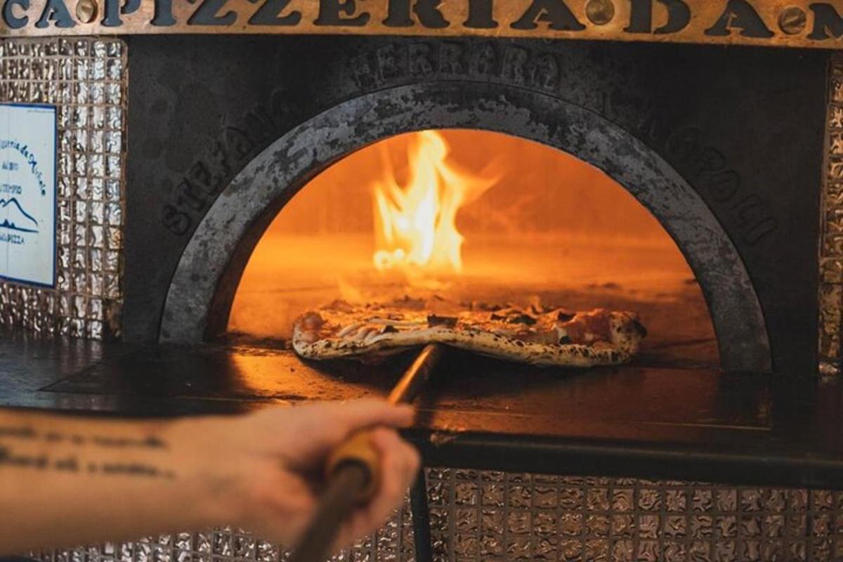 Una persona está metiendo una pizza en un horno.