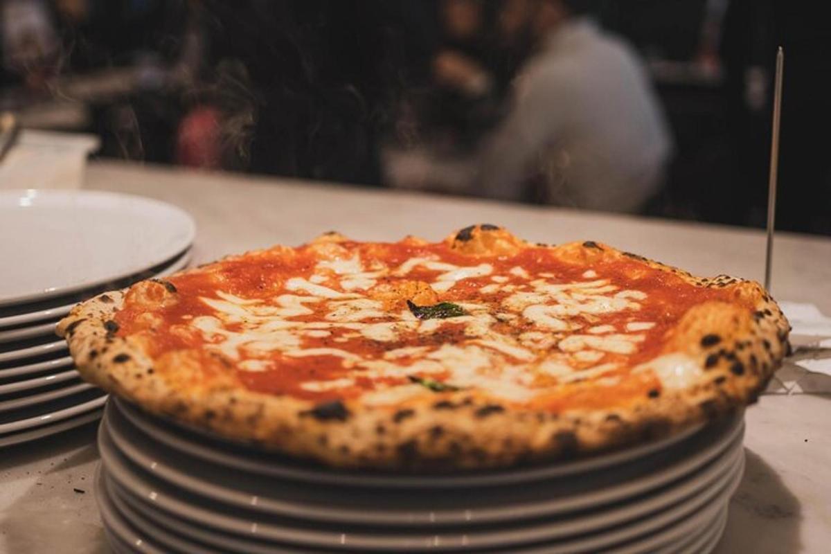een pizza die bovenop een stapel borden ligt
