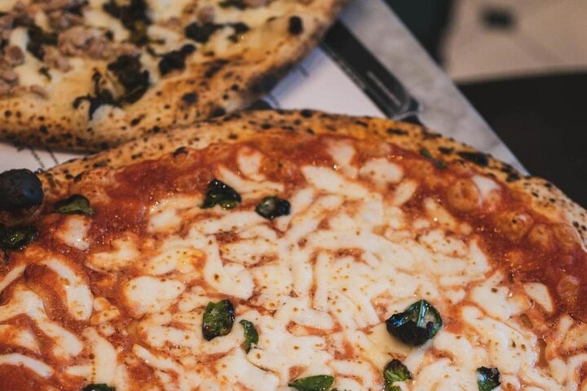 Dos pizzas colocadas una al lado de la otra en una mesa.
