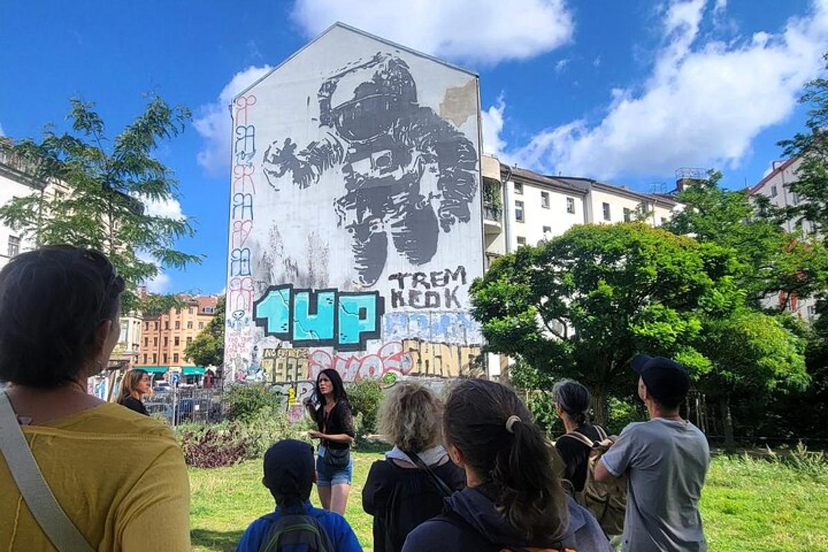 skupina lidí stojících před nástěnnou malbou