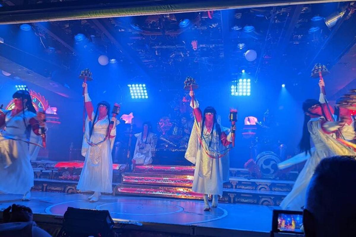 a group of people on a stage with their arms in the air
