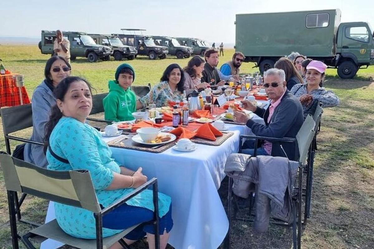 cilvēku grupa, kas sēž pie galda un ēd