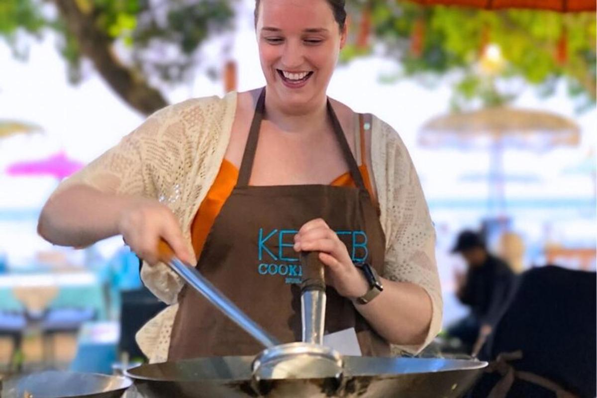 una donna con un grembiule che cucina in un wok