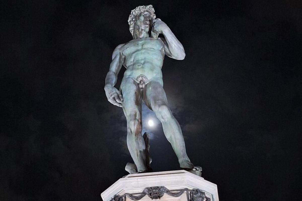 una estatua de un hombre parado en lo alto de un edificio
