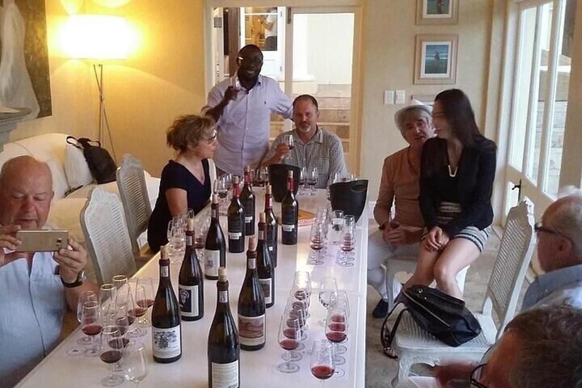 a group of people sitting around a table with bottles of wine