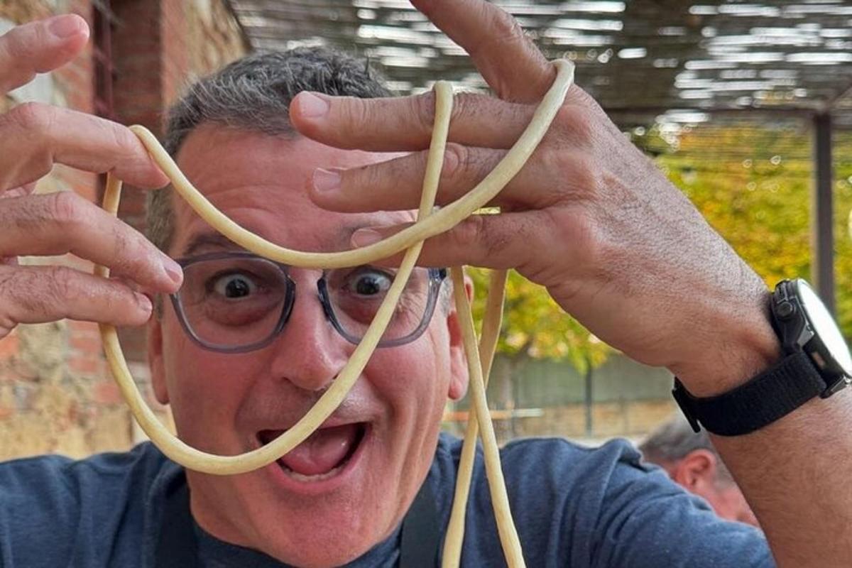 seorang lelaki memegang upalk spageti di mukanya