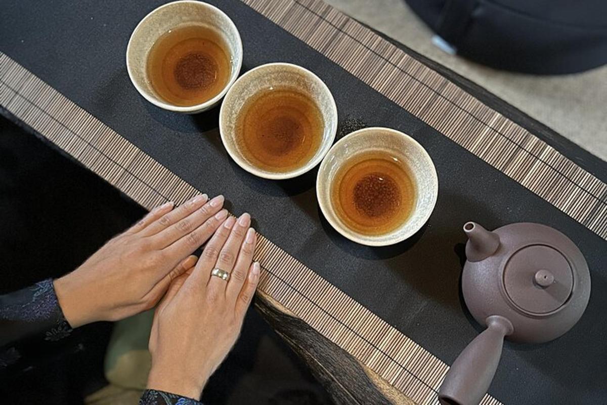 Kona með hendurnar á borði með fjórum bollum af kaffi