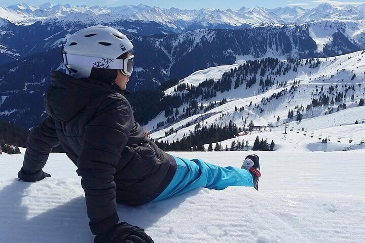 una persona seduta sulla neve su una montagna coperta di neve