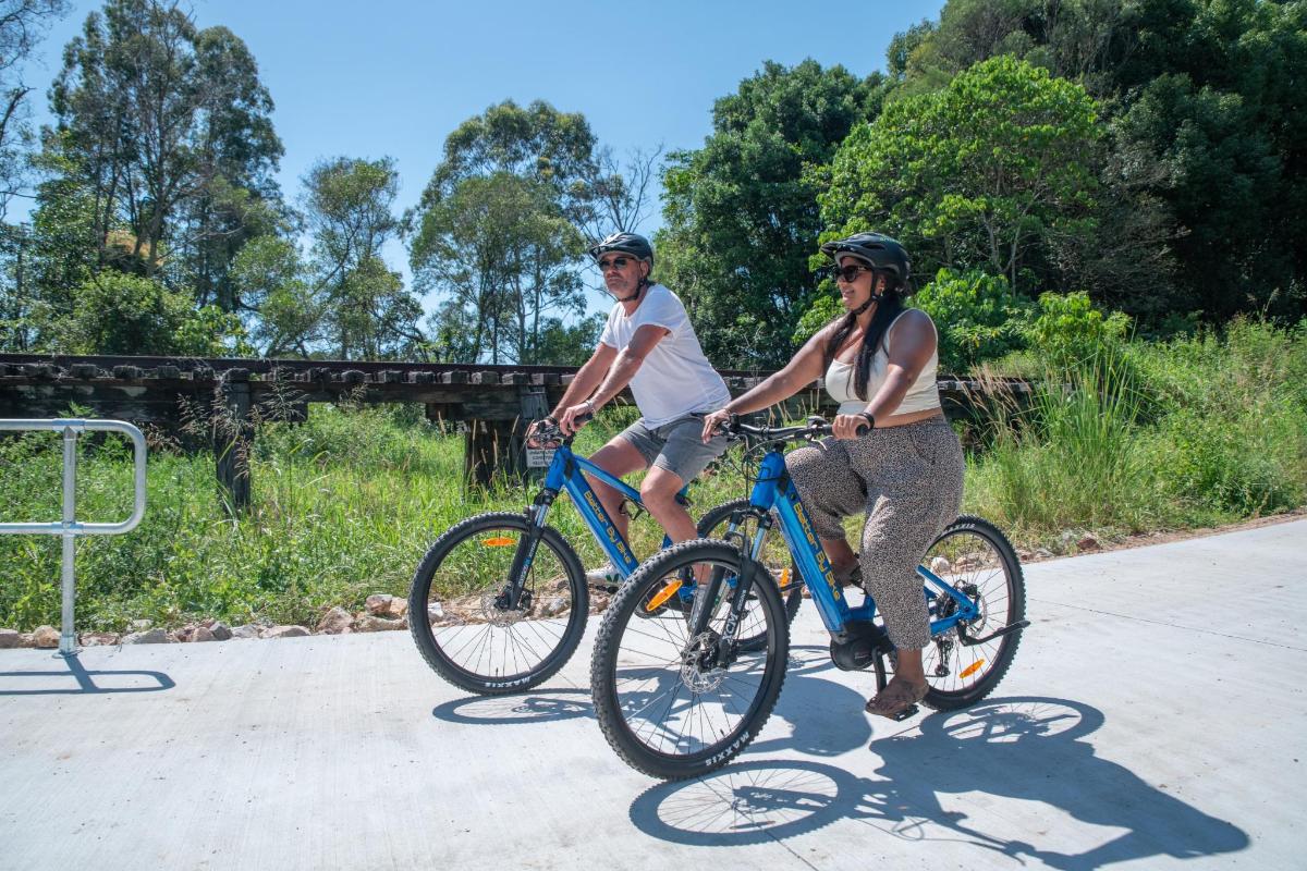 a man and a woman riding bikes down a road