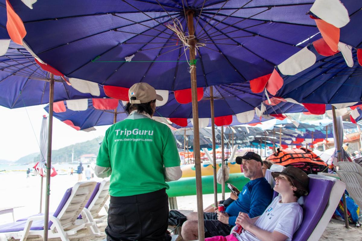 a group of people sitting under umbrellas on a beach