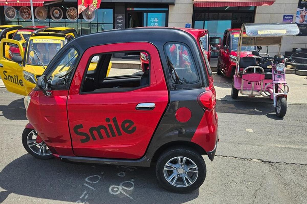 una piccola macchina rossa e nera parcheggiata in un parcheggio