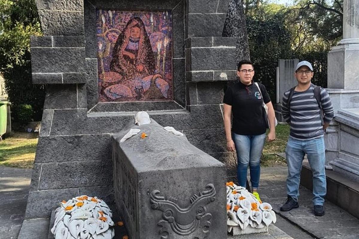 dois homens estão parados em frente a uma estátua