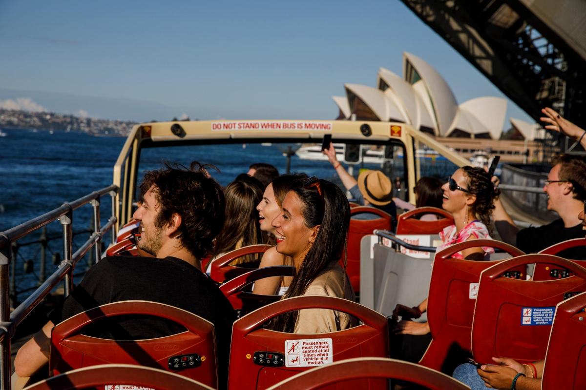 a group of people on a boat in front of the opera house