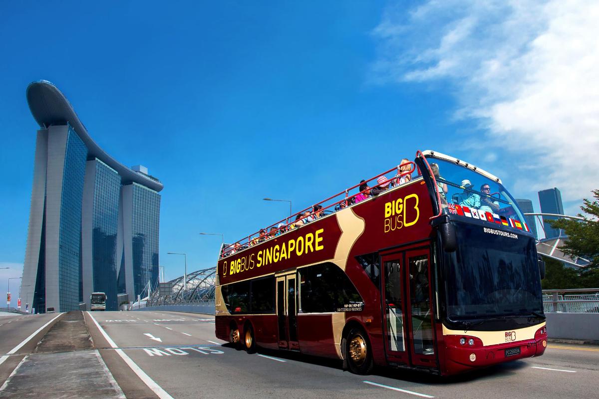 a red double decker bus driving down a street