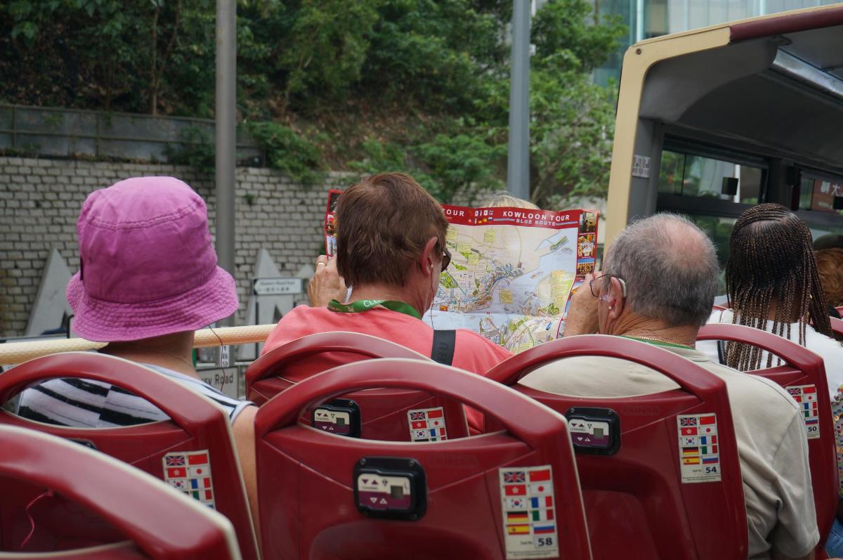 grupp inimesi istub bussis ja vaatab kaarti