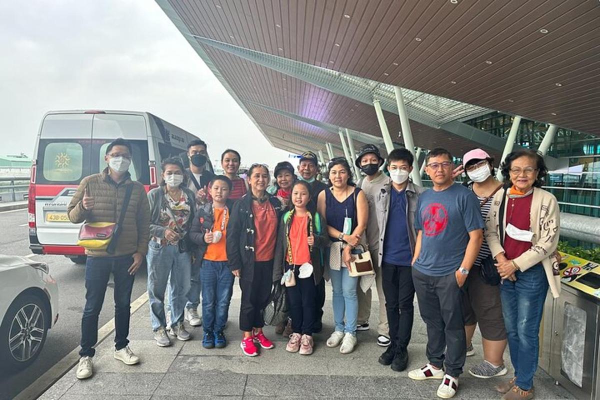 isang grupo ng mga taong nakasuot ng face mask na nakatayo sa tabi ng isang bus