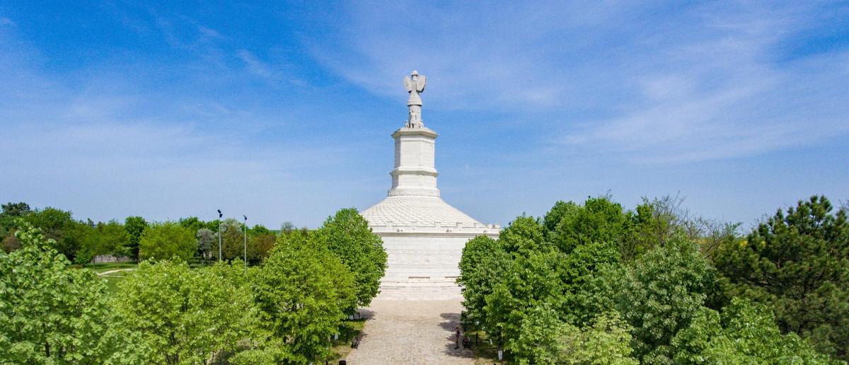 un monument mare și alb cu copaci în fața lui