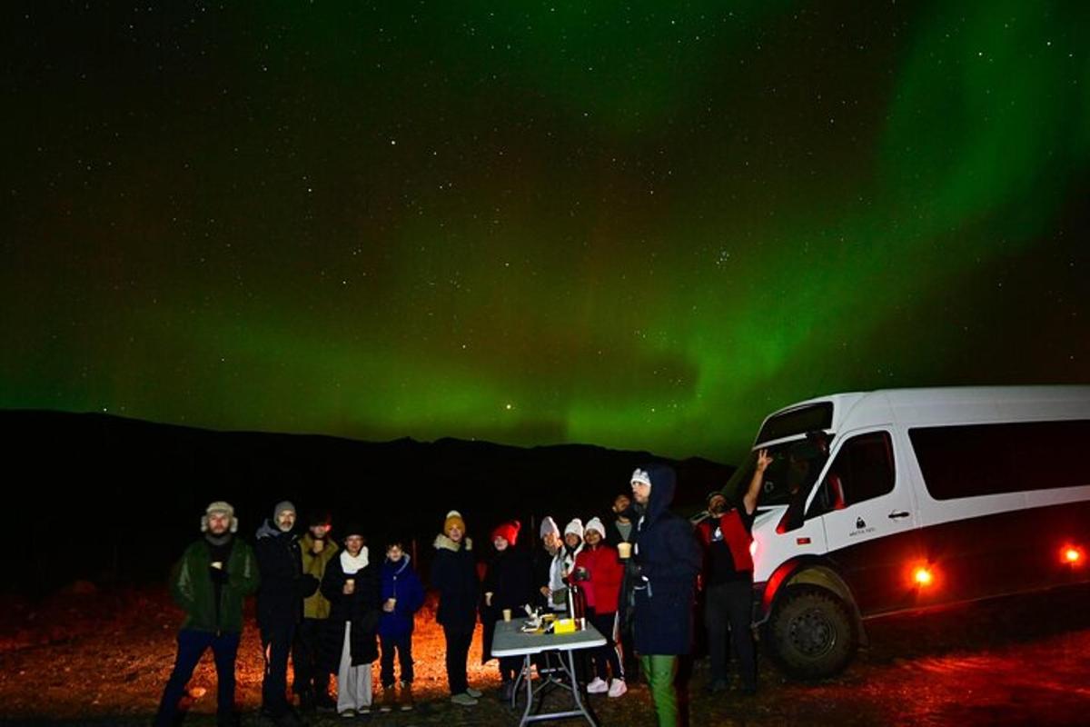 un gruppo di persone in piedi sotto l'aurora boreale