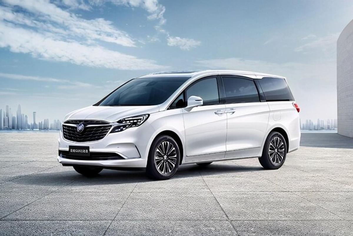 một chiếc xe hiệu Opel màu trắng đỗ trước một thành phố