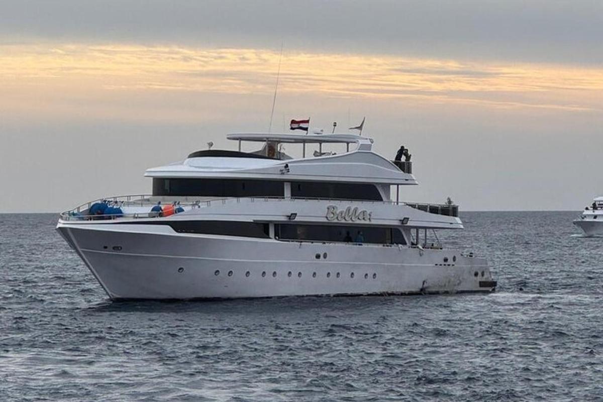 Un yate blanco en el agua con otros dos barcos.