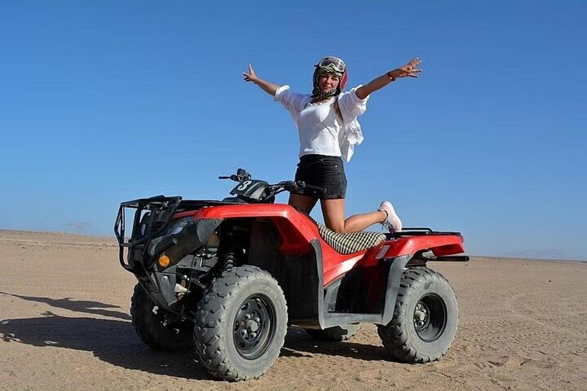 una donna seduta su un quad nel deserto