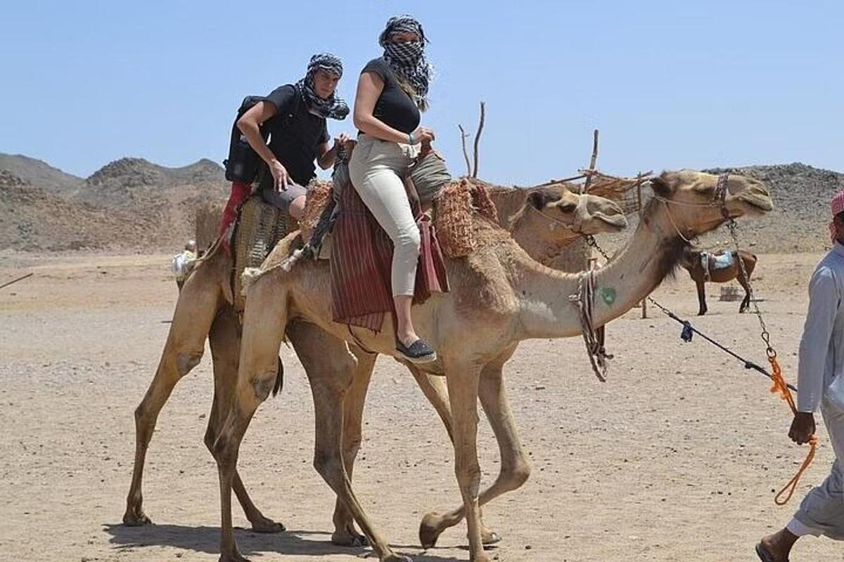 due persone a cavallo di un cammello nel deserto