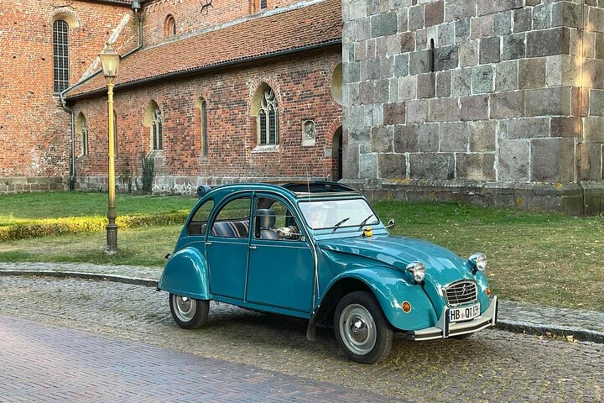 an old blue car parked in front of a building