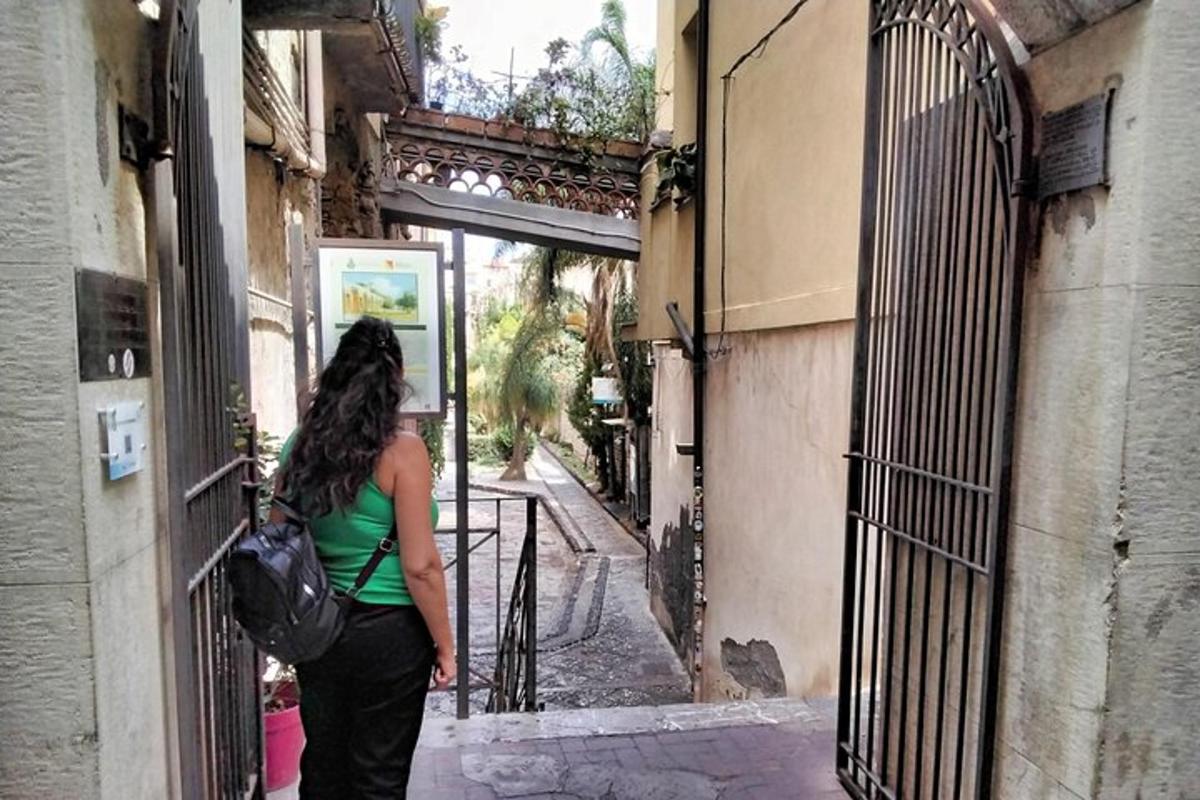 Una mujer parada en un callejón mirando por una puerta.
