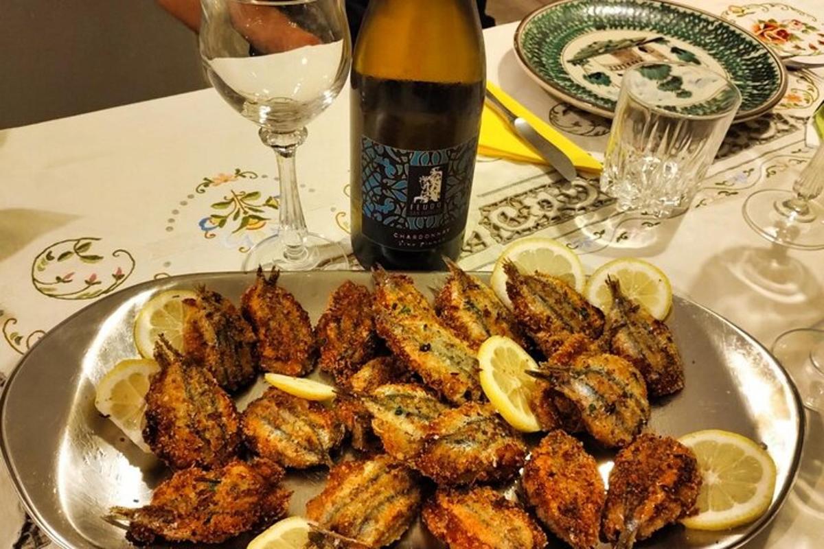 a plate of chicken with lemons and a bottle of wine