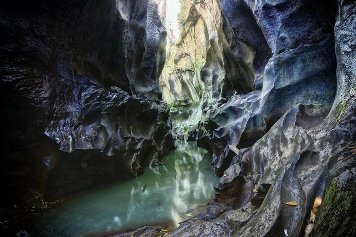 uma caverna com uma poça de água no meio