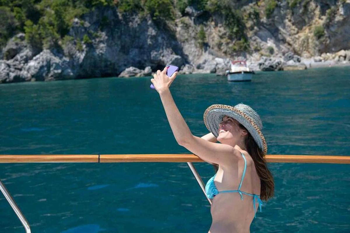 una donna in bikini che scatta una foto su una barca