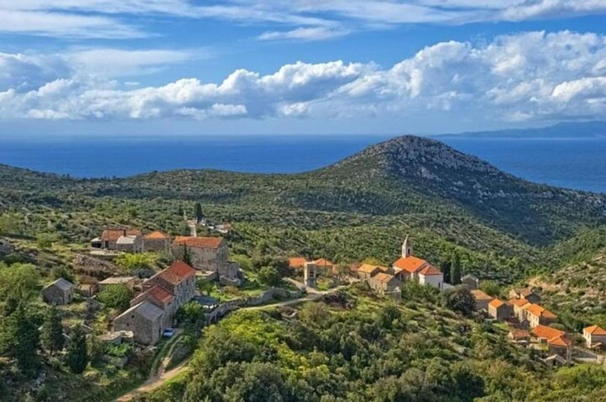 a village on a hill with the ocean in the background
